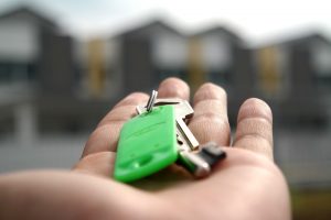 Outstretched hand holding keys. Home buyer beginners guide. 
