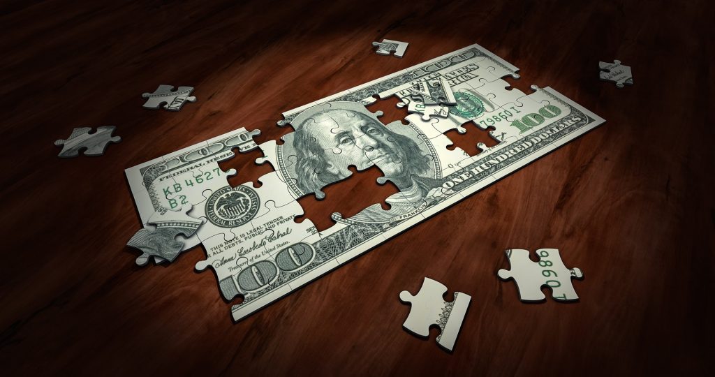Graphic of puzzle pieces making up a one hundred dollar bill. 